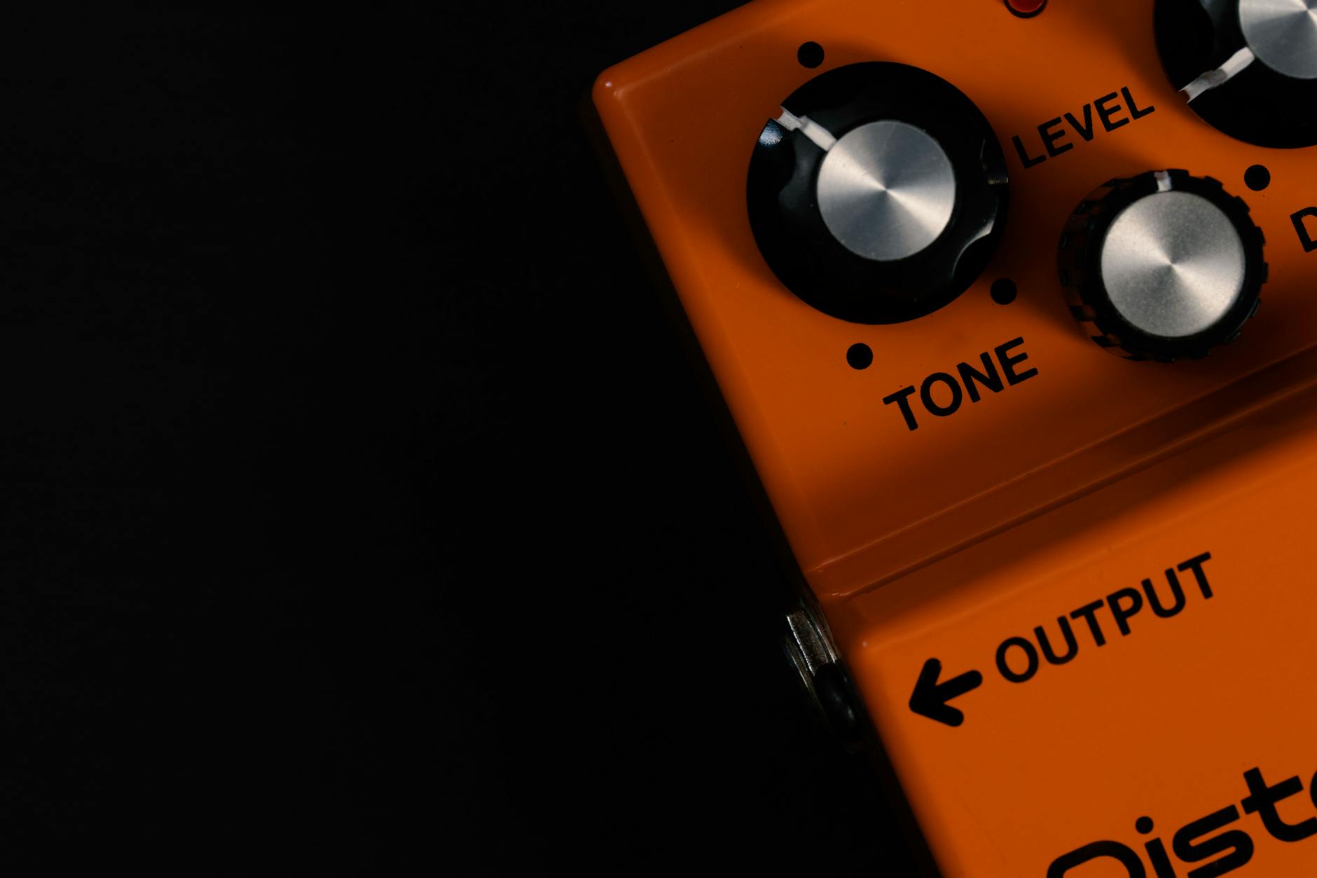 空間系エフェクター(ディレイ・リバーブ)のクローズアップ。LEVEL・TONEなどのノブと出力端子